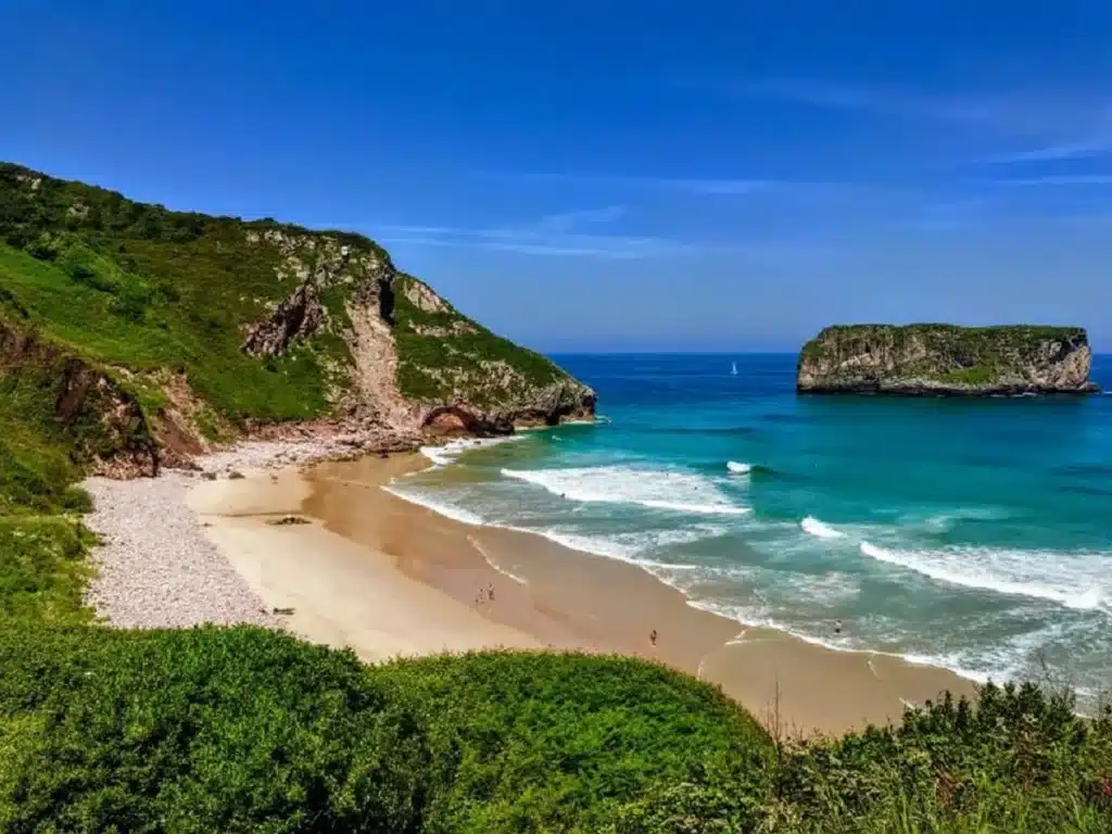 Imagen de la playa de Andrín con el Castro de Ballota detrás.