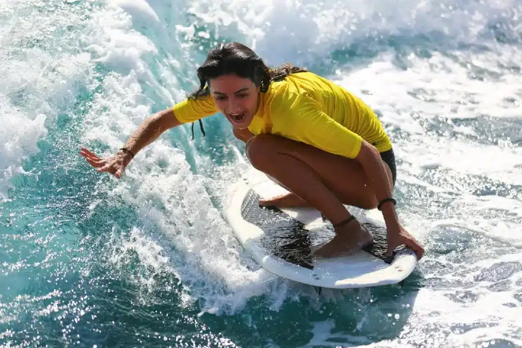 Imagen de una persona cogiendo una ola durante un curso de surf