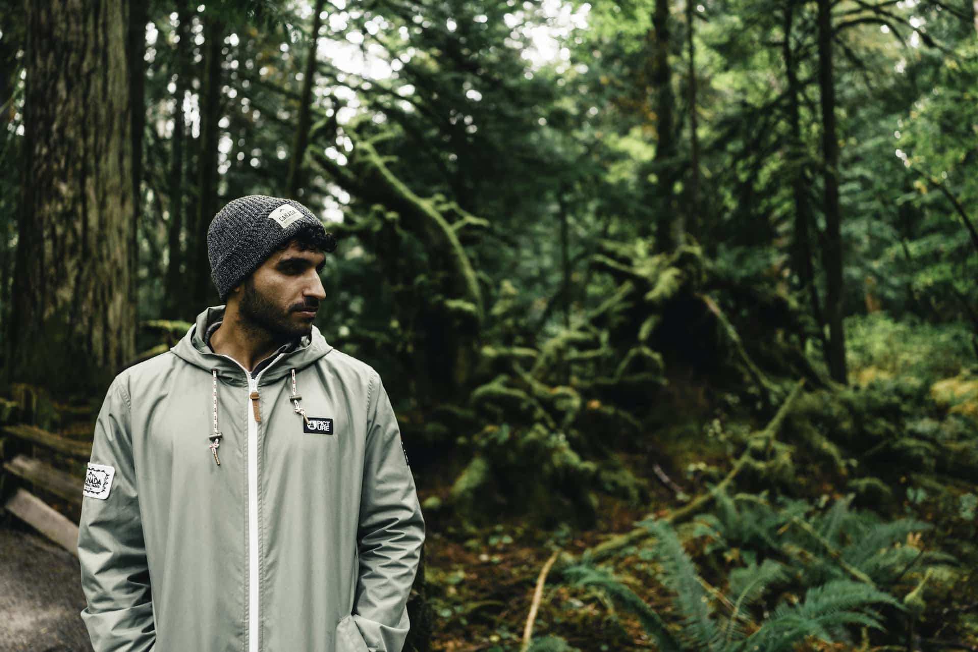 Senderista con gorro y chubasquero en un bosque húmedo, imagen del Black Friday senderismo