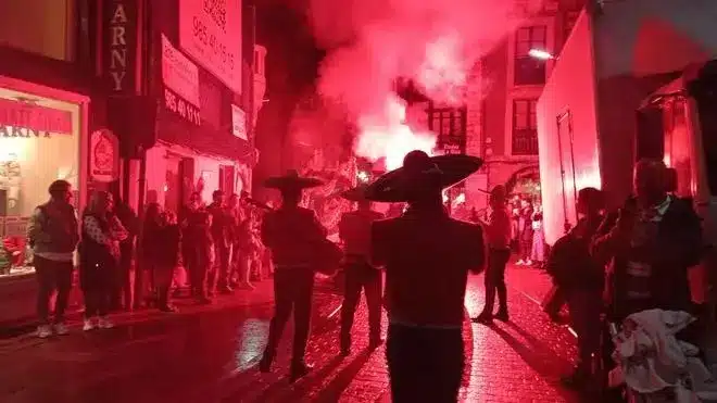 Desfile nocturno del Samaín por las calles de Llanes con mariachis y humo rojo
