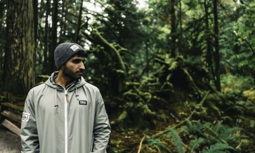 Senderista con gorro y chubasquero en un bosque húmedo, imagen del Black Friday senderismo
