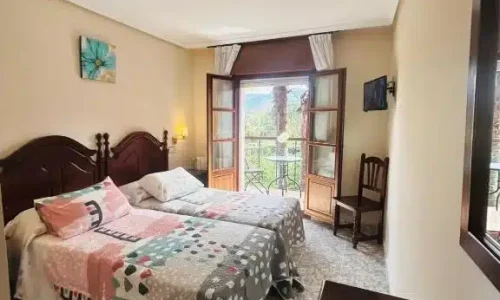 Habitación del Hotel Las Palmeras con balcón y vistas.