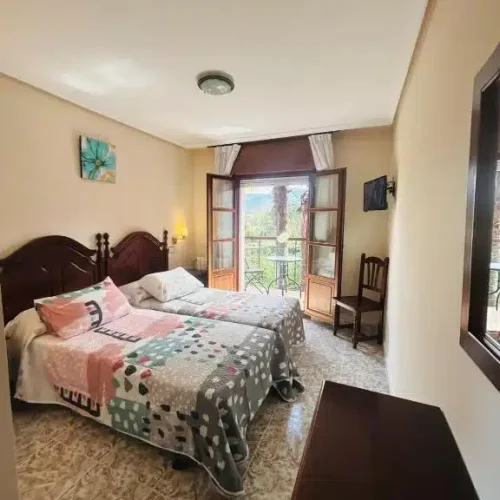 Habitación del Hotel Las Palmeras con balcón y vistas.