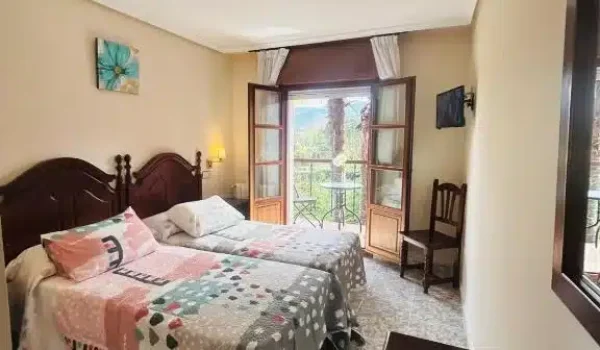 Habitación del Hotel Las Palmeras con balcón y vistas.