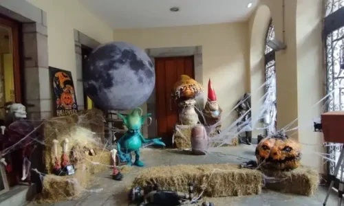 Pórtico decorado para Halloween en Llanes con una luna gigante, calabazas y telarañas