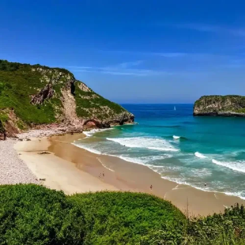 Imagen de la playa de Andrín con el Castro de Ballota detrás.