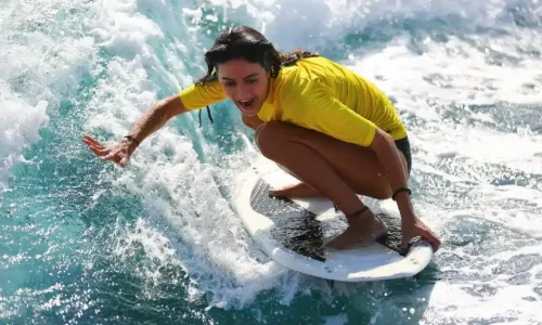 Imagen de una persona cogiendo una ola durante un curso de surf