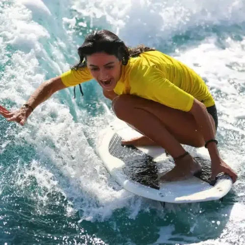 Imagen de una persona cogiendo una ola durante un curso de surf