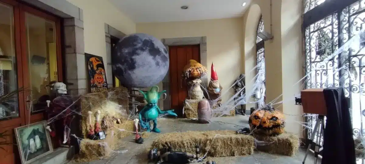 Pórtico decorado para Halloween en Llanes con una luna gigante, calabazas y telarañas